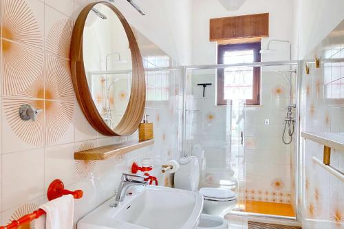 a bathroom with a sink and a mirror and a toilet at Villa Elena - Seafront & Comfort by Salento Prime in Torre Vado