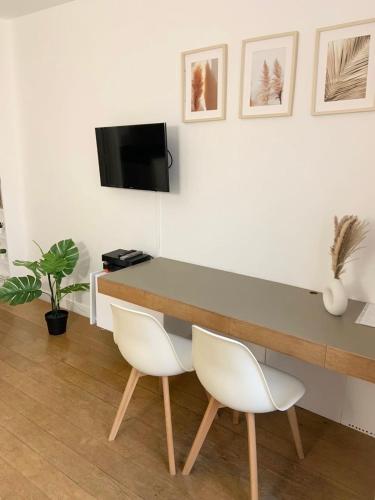 - un bureau avec 2 chaises blanches dans l'établissement Studio panthéon, à Paris