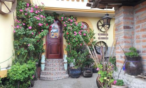 a door with flowers on the side of a house at Hostal Curiñan in Otavalo