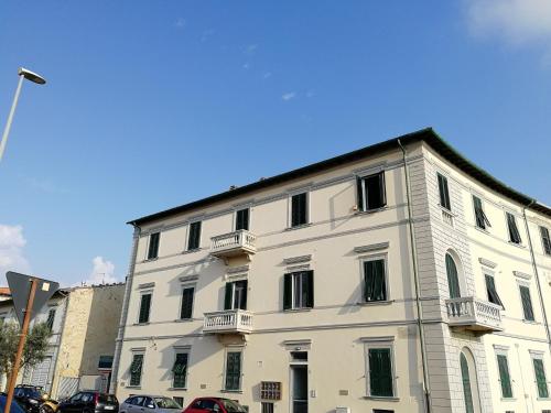 a white building with black windows on a street at Tramonti sul mare in Marina di Pisa