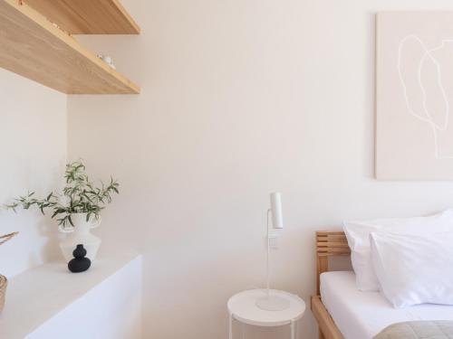 a white bedroom with a bed and a table at Resort po.spolu in Mokrovraty