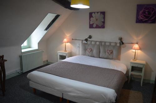 a bedroom with a bed and two lamps on two tables at Le Relais du Morvan in Vézelay