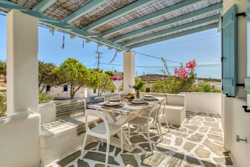 a patio with a table and chairs on a balcony at Onikos House - South Gem in Kampos Paros