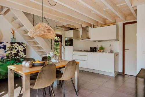a kitchen and dining room with a wooden table and chairs at Dutchen Vakantiepark Buiten Bergen in Schoorl