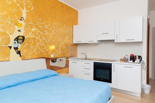 a bedroom with a bed and a kitchen with white cabinets at La Dimora Degli Artisti in Catanzaro