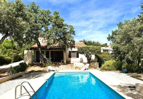 une piscine devant une maison avec des arbres dans l'établissement Le Plantier, maison pour 6 personnes avec piscine et jardin vue mer à La Londe-Les-Maures, à La Londe-les-Maures