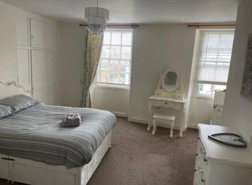 a bedroom with a bed and a desk with a mirror at Lake District 2bed Apartment in Workington