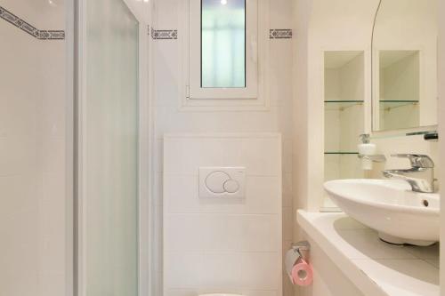une salle de bain blanche avec un lavabo et une douche dans l'établissement B024 - Magnifique Villa - Piscine - Cannes centre, à Cannes