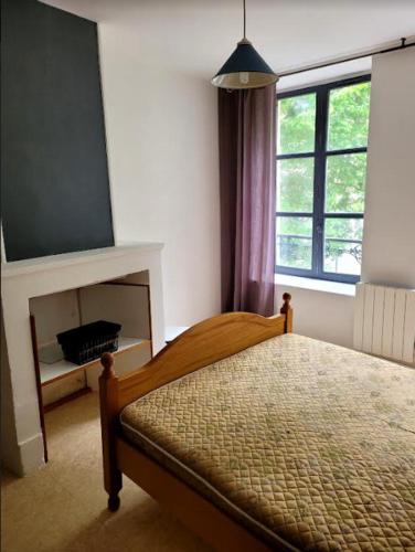 - une chambre avec un lit, une cheminée et une fenêtre dans l'établissement La Halle qui mène au Château, à Sedan