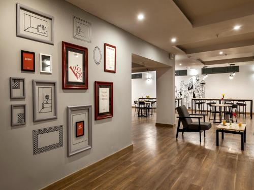 a room with a wall with pictures on it at Palette - Hotel Saket Greens in Bhopal