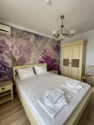 a bedroom with a large bed with a floral wall at Admiral Plaza Apartments in Sunny Beach
