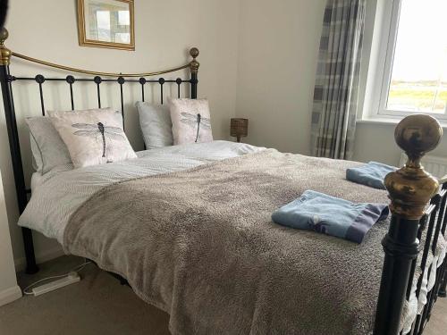 a bed with two pillows on it in a bedroom at Luxury Beachfront The Cozy Clam in Pevensey