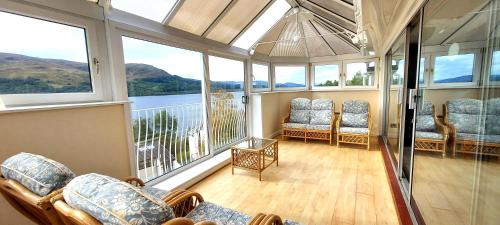 a room with chairs and windows with a view at Loch Rannoch Highland Club in Kinloch Rannoch