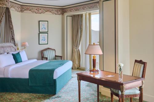 a hotel room with a bed and a desk and a table at Hilton Cairo Grand Nile in Cairo