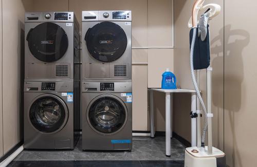 two washers and a dryer in a room at Xiamen Evening Breeze Hotel in Xiamen