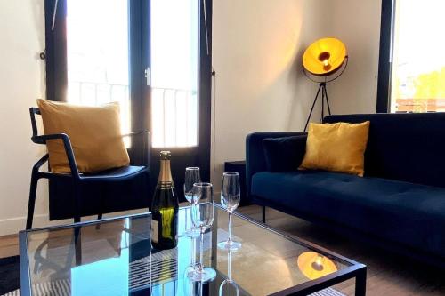 un salon avec un canapé bleu et une table en verre dans l'établissement Casa Amarelo, à Angers