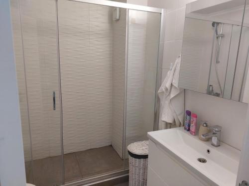 a white bathroom with a shower and a sink at Apartament Solid Resindence Butoaie in Mamaia