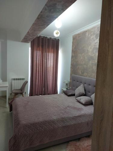 a bedroom with a large bed and a window at Apartament Solid Resindence Butoaie in Mamaia