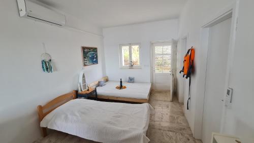 a white room with two beds and a window at Villa More in Postup