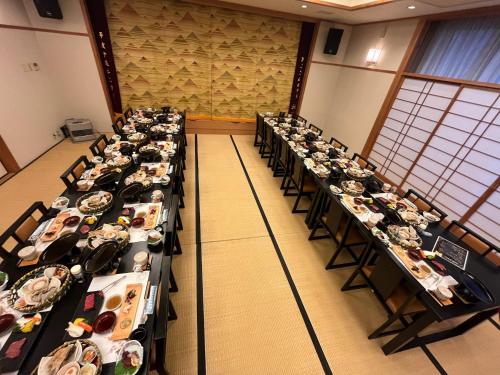 a group of tables in a room filled with food at ひこさんホテル和 in Hikosan