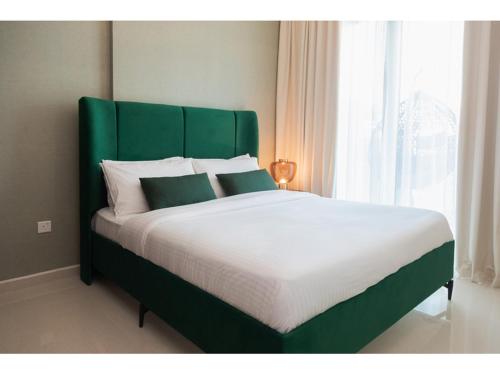 a large bed with a green headboard in a bedroom at Luxury 1-Bedroom Apartment with Pool, Gym & Balcony in Business Bay in Dubai
