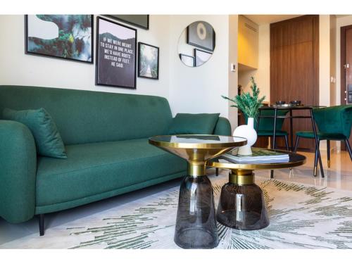 a living room with a green couch and a gold table at Luxury 1-Bedroom Apartment with Pool, Gym & Balcony in Business Bay in Dubai
