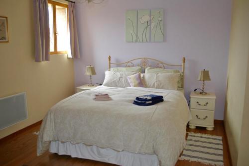 une chambre avec un grand lit avec des draps et des oreillers blancs dans l'établissement Les Gîtes Champêtres OAK Cottage, à Sainteny