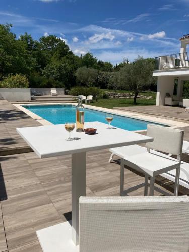 - une table et des chaises blanches à côté de la piscine dans l'établissement Rez-de-chaussée de villa 45m2, piscine, climatisation, parking, à Aix-en-Provence