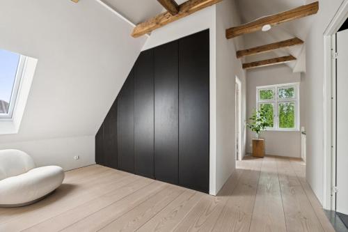 a living room with a black door and a white wall at Elegant Luxury Villa in the Heart of Aarhus in Aarhus