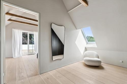 a white room with a mirror and a white chair at Elegant Luxury Villa in the Heart of Aarhus in Aarhus