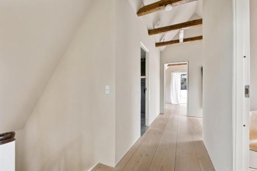 a hallway with white walls and a wooden floor at Elegant Luxury Villa in the Heart of Aarhus in Aarhus