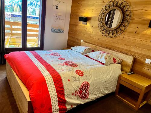 a bedroom with a bed with a red and white blanket at Le REFUGE DES PORTES DU MONT BLANC in Vallorcine