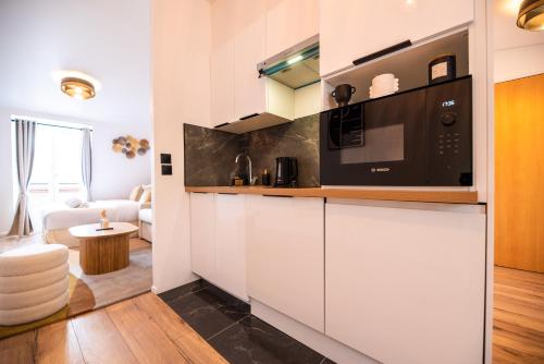 une cuisine avec des armoires blanches et un micro-ondes dans l'établissement CIA - Champs Élysées Bright Studio 4P, à Paris