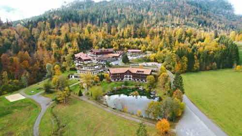 an aerial view of a large house with a lake at Feuriger Tatzlwurm Berghotel & Spa, BW Signature Collection in Oberaudorf