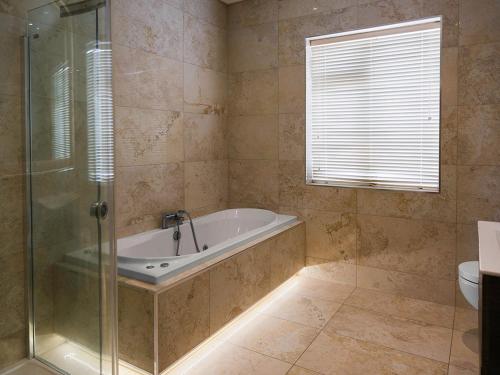 a bathroom with a tub and a glass shower at Dawn Chorus house, Ravensdale in Dundalk