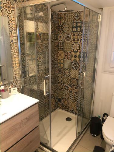 une salle de bain avec une douche avec un lavabo et des toilettes dans l'établissement Dinard-jolie maison au calme proche plage, à Dinard