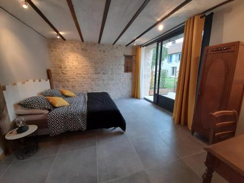 une chambre avec un lit et une grande fenêtre dans l'établissement Gîte des Sources-Rumont, à Rumont