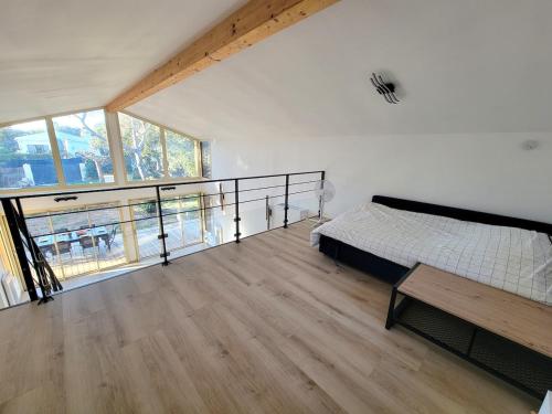 une chambre avec un lit et une grande fenêtre dans l'établissement Villa Lou Pantaï la tranquillité à 2 pas de la mer, à Saint-Aygulf