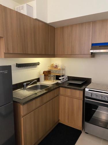 a kitchen with wooden cabinets and a sink and a stove at Jungle Escape in Manila