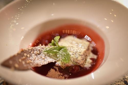 a white bowl of soup with food in it at Feuriger Tatzlwurm Berghotel & Spa, BW Signature Collection in Oberaudorf