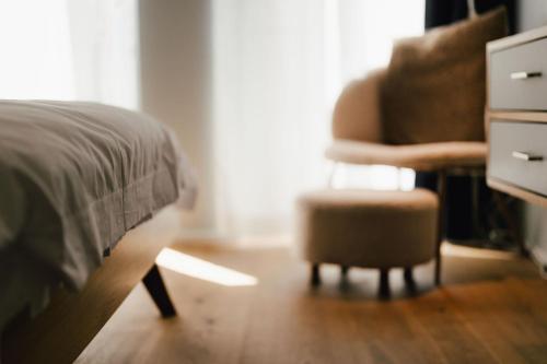 a bedroom with a bed and a chair and a dresser at The Layhead B&B in Lübeck