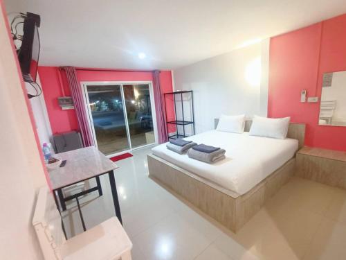 a bedroom with a bed and a red wall at Saan Rak Resort in Prachuap Khiri Khan