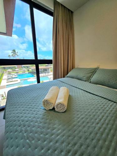 a bedroom with a bed with two towels on it at Sofisticação e Luxo à Beira-mar no Cais Eco em Muro Alto by HM in Porto De Galinhas