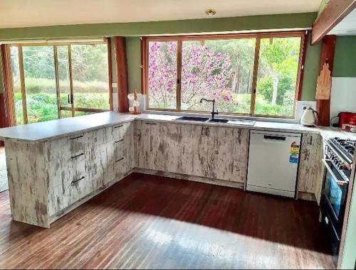 a kitchen with a counter top and some windows at Pemberton Forest View Retreat in Pemberton