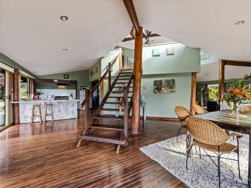 a living room with a staircase and a table and chairs at Pemberton Forest View Retreat in Pemberton