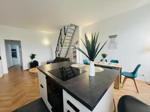 - une cuisine et un salon avec un vase sur un comptoir dans l'établissement Casa Bressigny, à Angers