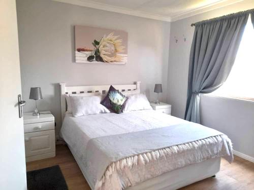 a bedroom with a large white bed and a window at Seaview at it’s best in Hentiesbaai