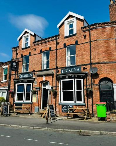 a brick building with a sign in front of it at The Charles Dickens Hotel in Wigan