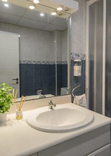 a bathroom with a sink and a large mirror at Apartamento cerca del Pilar in Zaragoza
