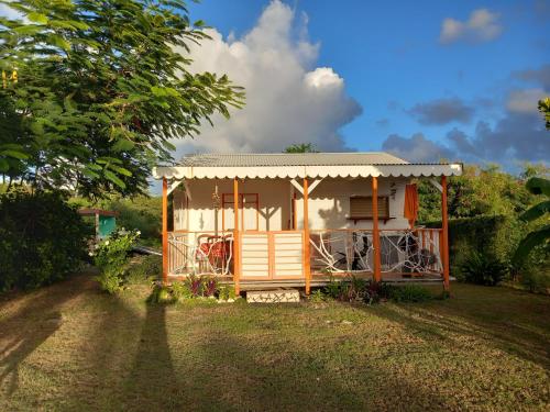 a small house in a yard with a tree at Bungalow au soleil in Saint-François